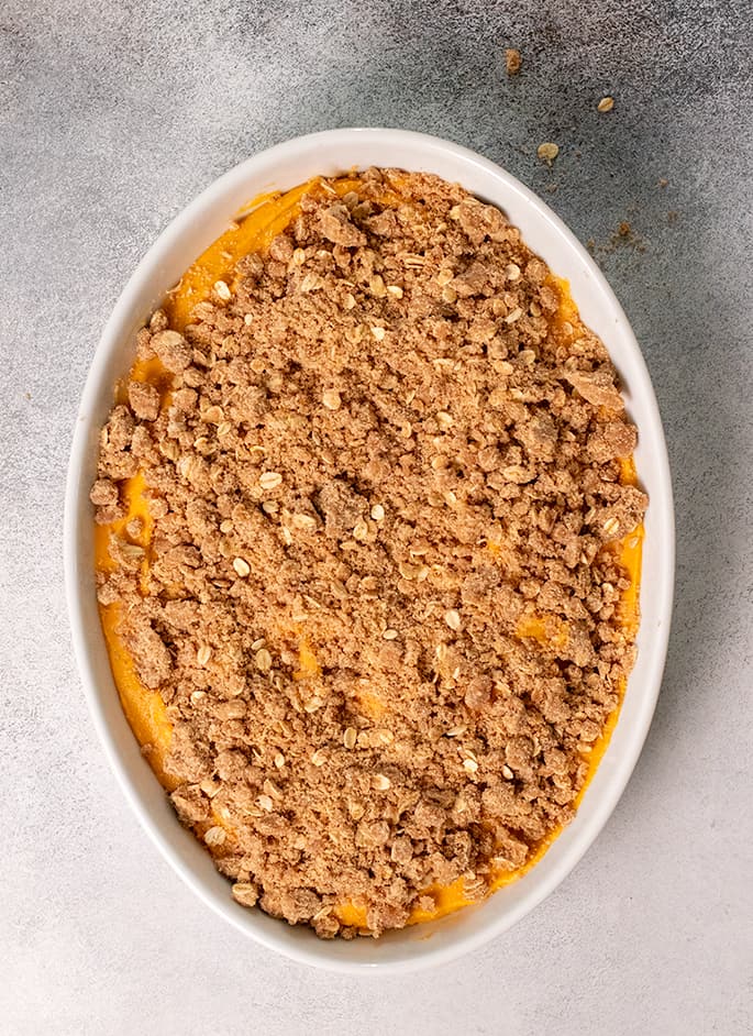 Sweet potato casserole unbaked in white baking dish overhead image