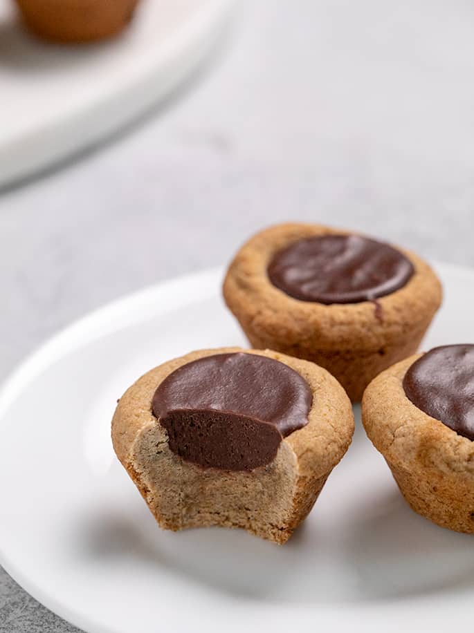 3 Gingerbread fudge puddles on a small white plate one with a piece missing