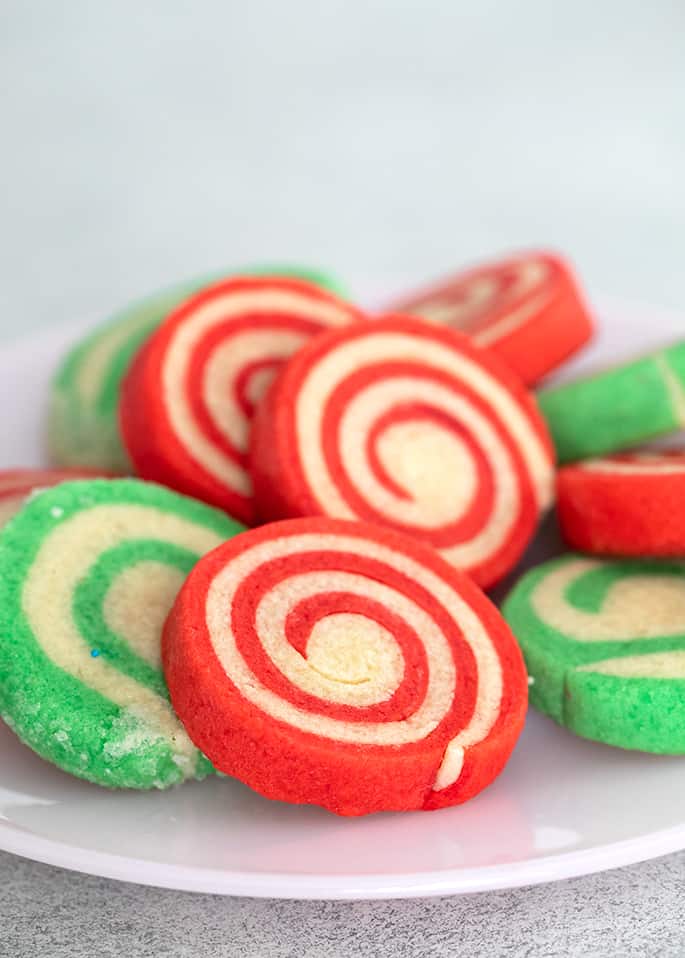 Plate of white and green striped and white and red striped pinwheel cookies