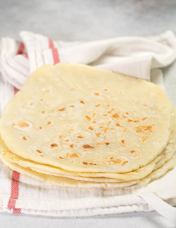 Stack of 4 flatbreads in a white tea towel with a red stripe