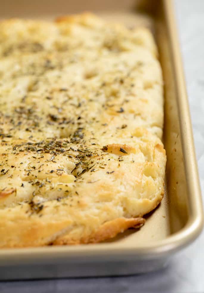 Uncut baked focaccia in baking pan