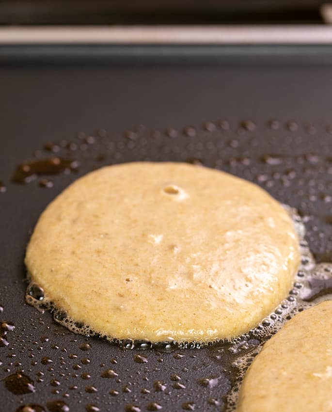 Raw banana pancakes cooking on skillet