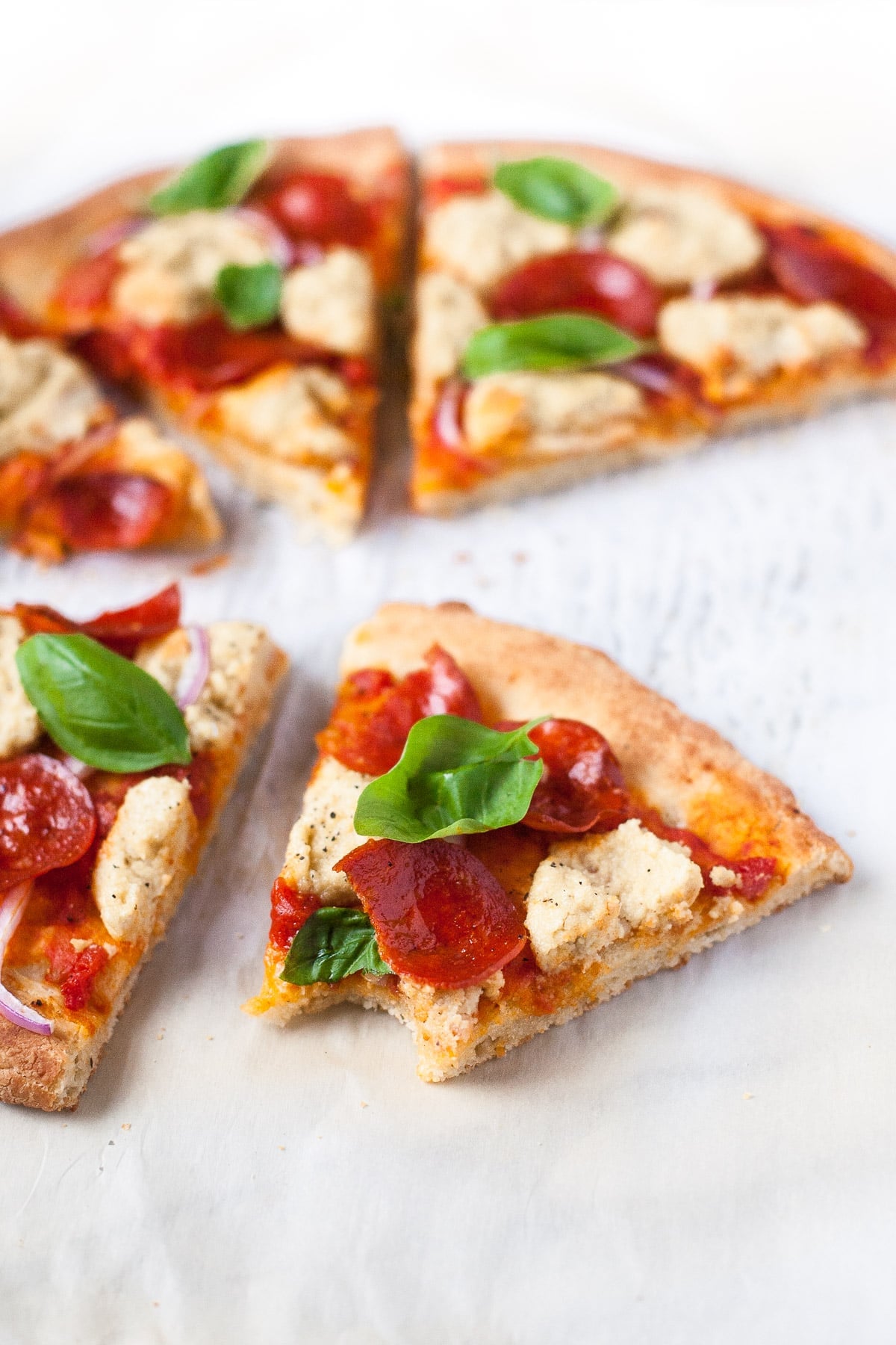 A slice of Paleo pizza with a bite taken