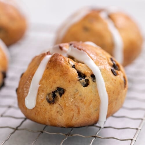 gluten free hot cross buns with white icing cross with raisins on wire rack