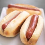 3 gluten free hot dog buns with hot dogs