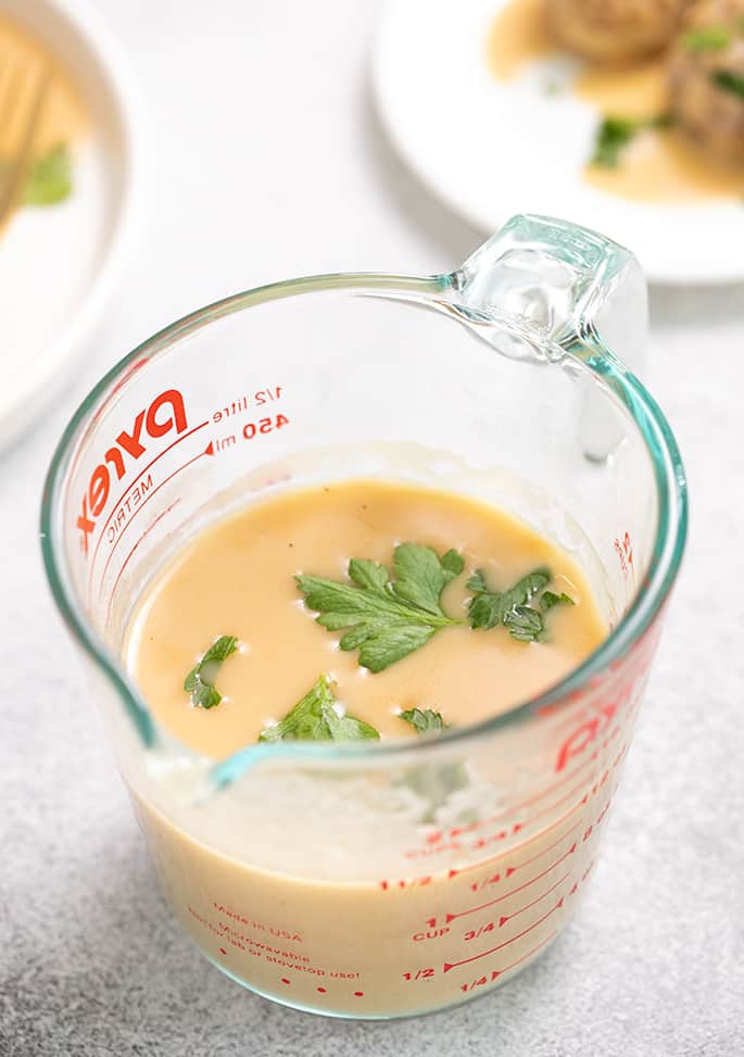 Pyrex mixing cup with gravy and flat leaf parsley