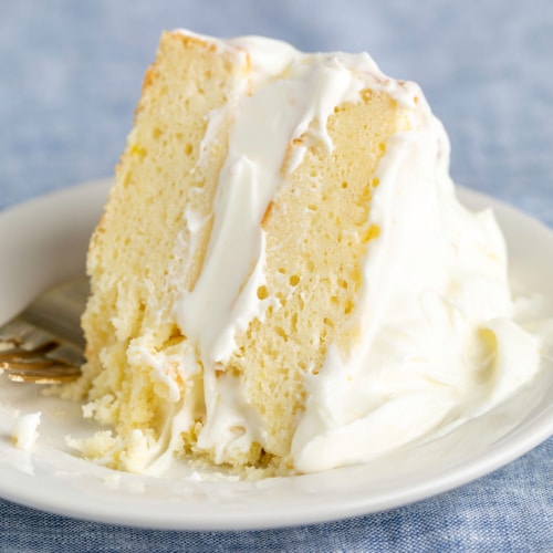 slice of 2 layer lemon cake with white filling and frosting