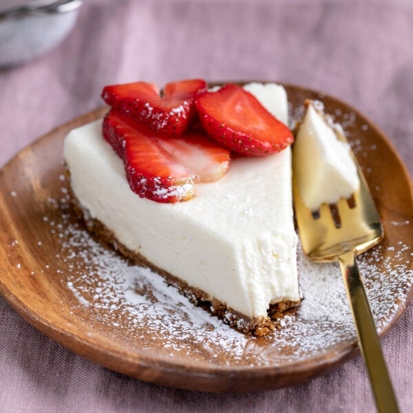 slice of no bake cheesecake with gelatin on brown plate with forkful taken