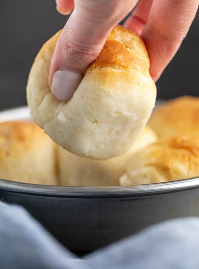 closeup image of fingers squeezing baked dinner roll