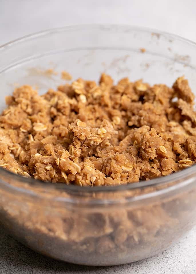 Raw crisp with rolled oats in small glass bowl for gluten free peach crisp topping