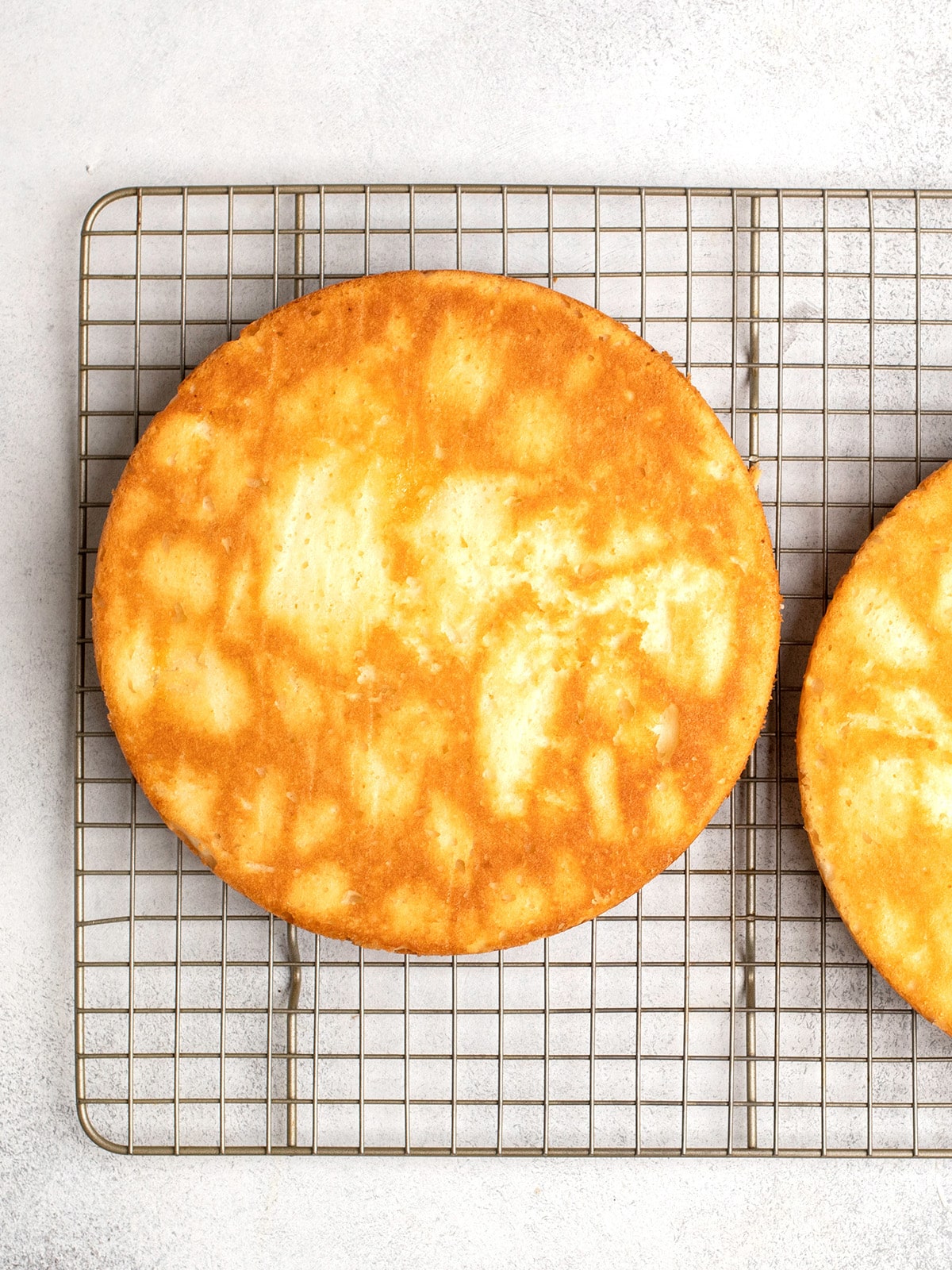 Overhead image of round gluten free yellow cake on wire rack
