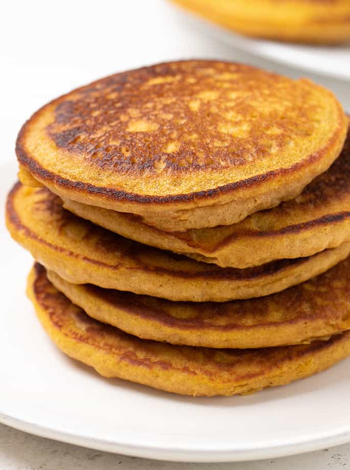 Stack of 5 pumpkin pancakes on white plate