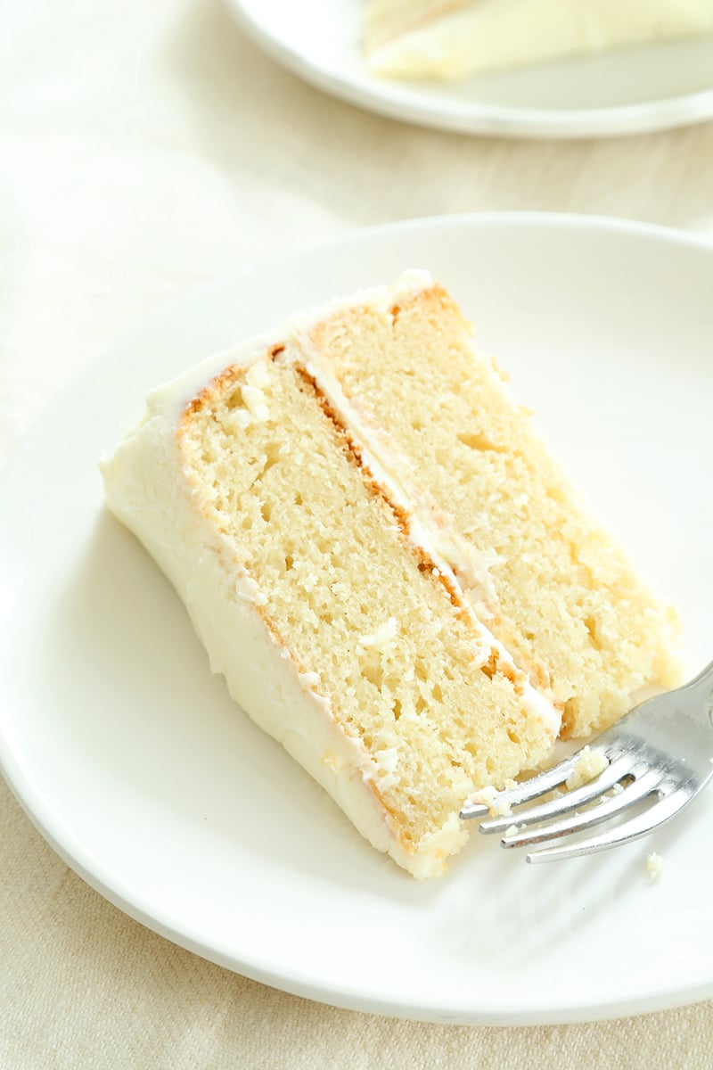 round yellow gluten free cake on white plate with a fork