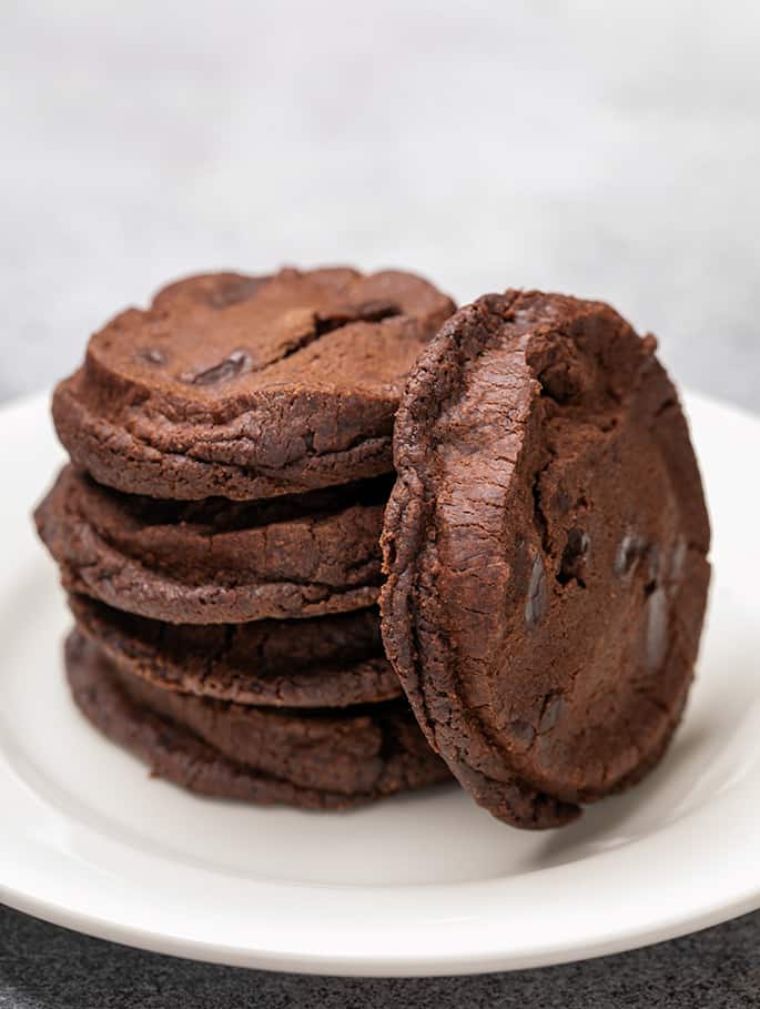 Stack of 4 brown cookies with a 5th leaning on the stack