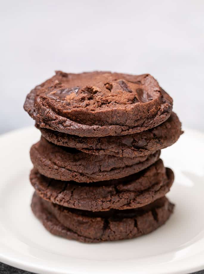 Stack of 5 round brown cookies on a small white plate