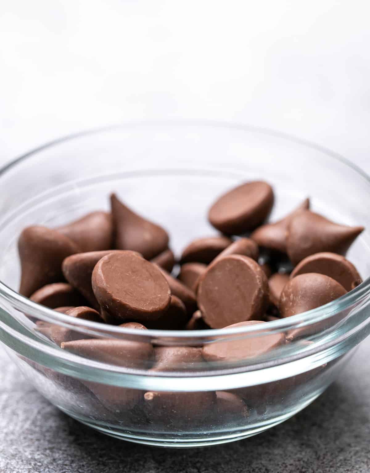 Small glass bowl with unwrapped Hershey's chocolate kisses