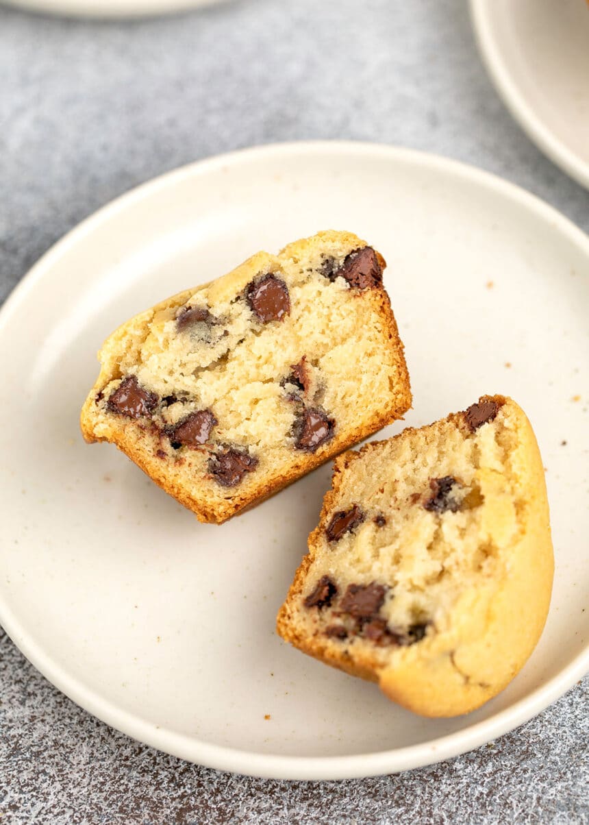 chocolate chip muffin sliced in half on white plate