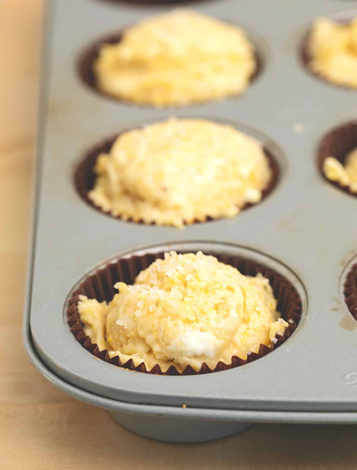 Raw corn muffin batter in muffin wells