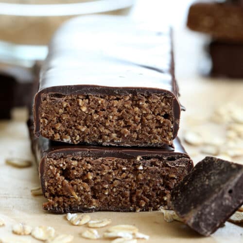 stack of 2 protein bars with chocolate coating on brown paper