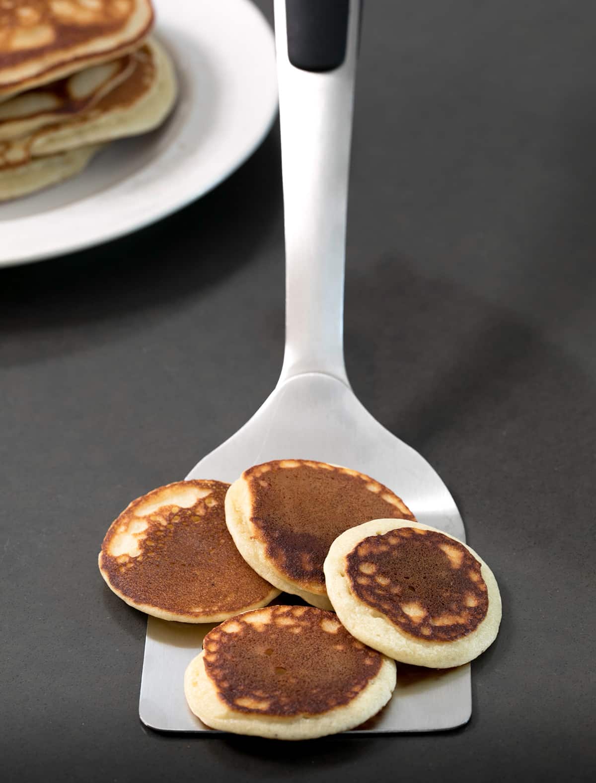 mini brown Paleo pancakes on large metal spatula