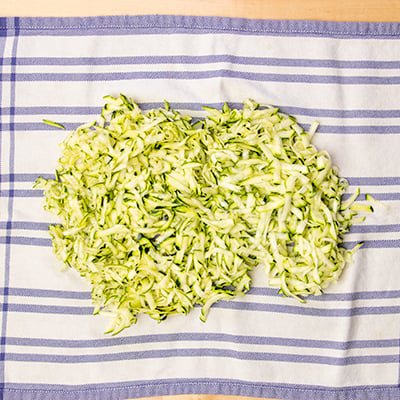 Shredded zucchini on blue and white striped towel