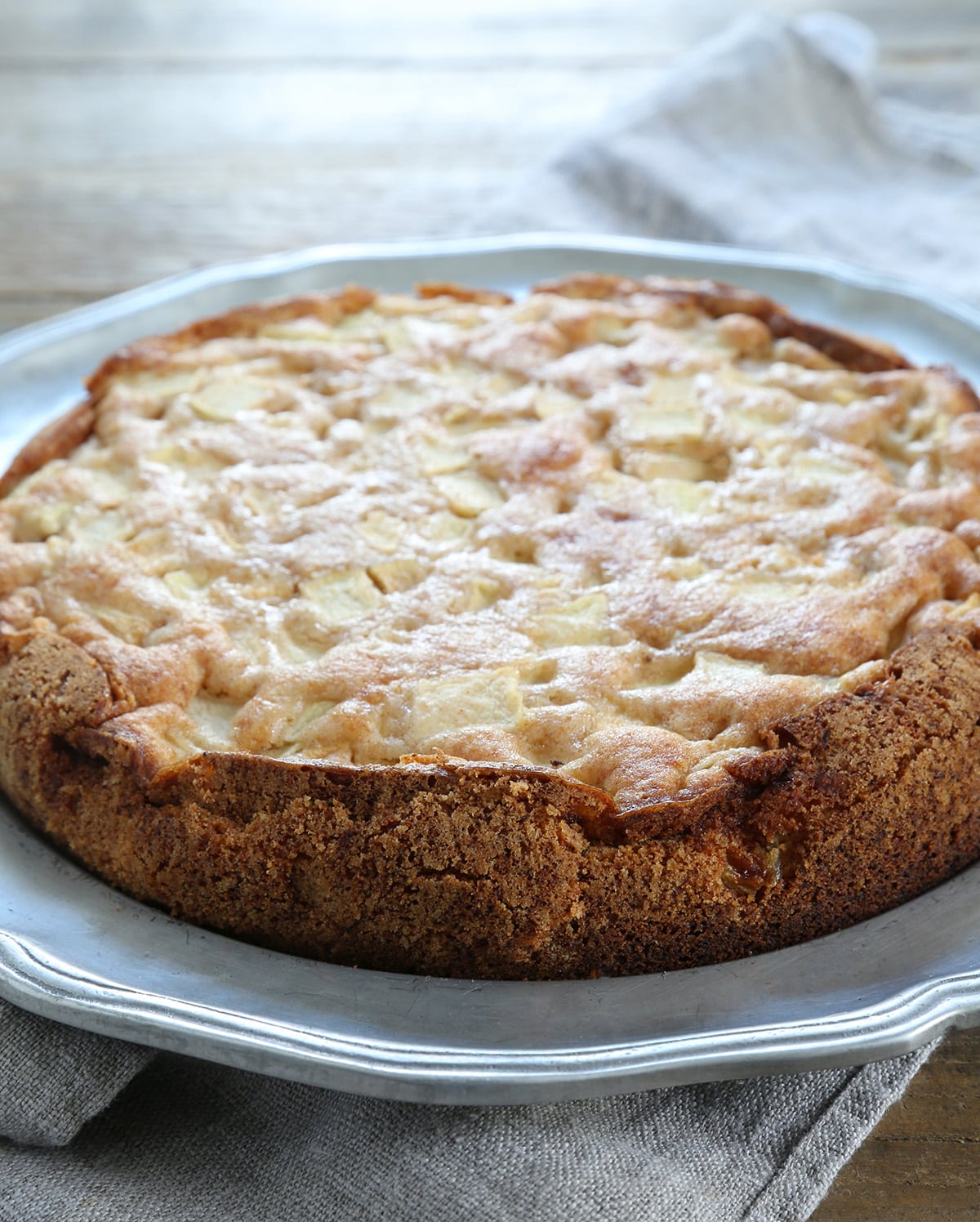 A close up of an apple cake on a silver surface 
