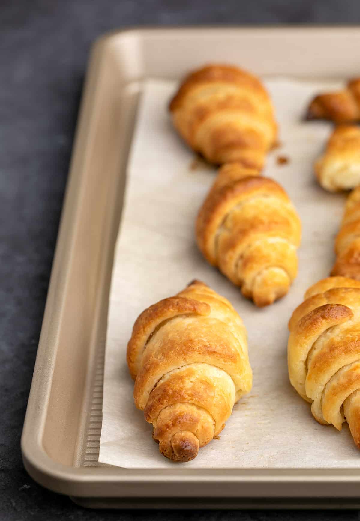 Closeup of baked croissants on white paper on tray