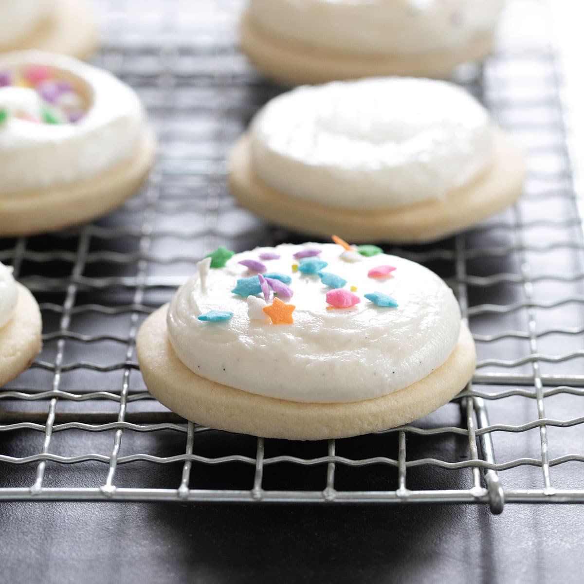 6 gluten free sugar cookies with frosting on wire rack