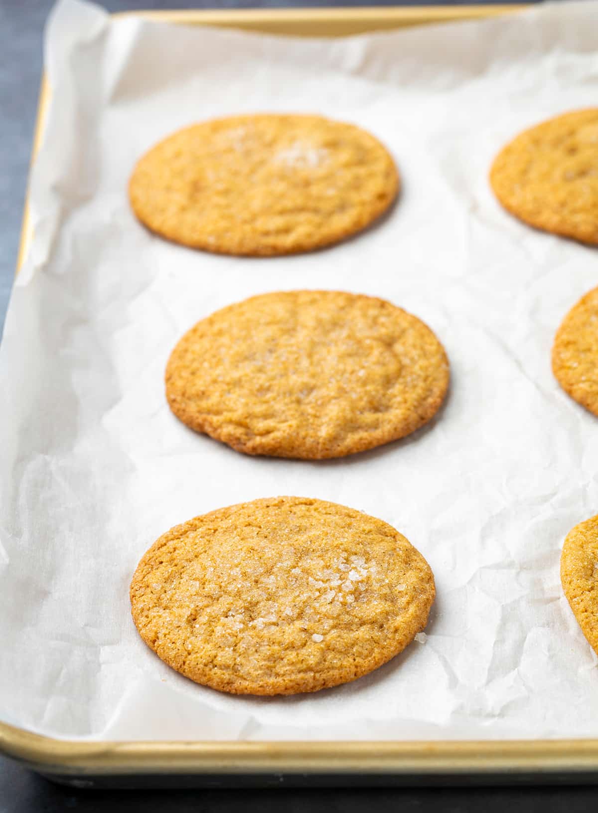 Baked soft ginger cookies on white paper on gold tray