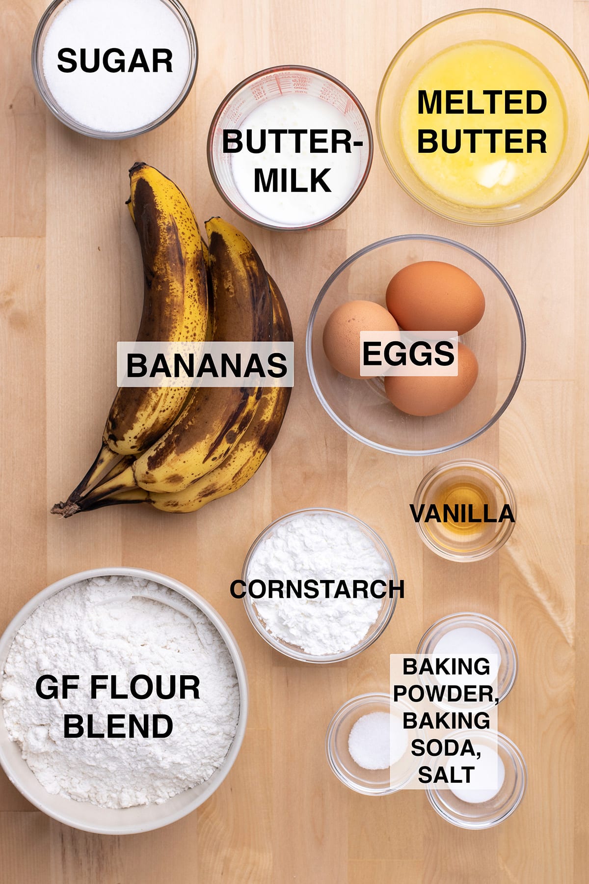 Ingredients required in small glass bowls and on blond wood table.
