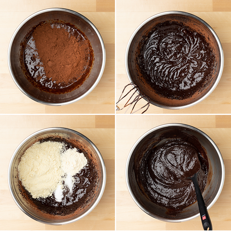 mixing bowl with cocoa powder on top of chocolate batter, mixing in almond flour, coconut flour baking powder, and salt with black spatula