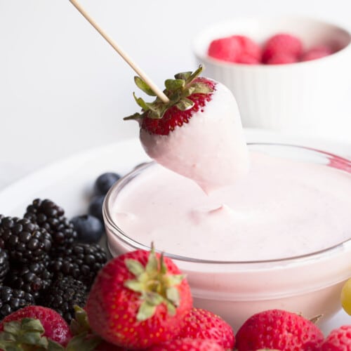 strawberry dipping in pink fruit dip