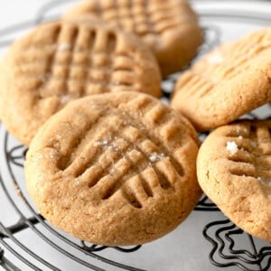 pile of flourless peanut butter cookies on black wire rack