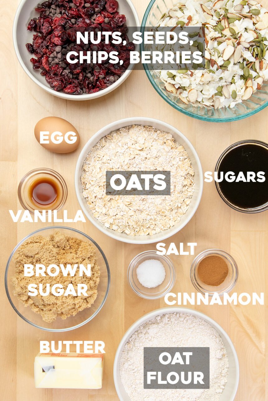 ingredients of homemade chewy gluten free granola bars, with words nuts, seeds, chips, berries, egg, oats, oat flour, sugars, vanilla, brown sugar, salt, cinnamon, butter.