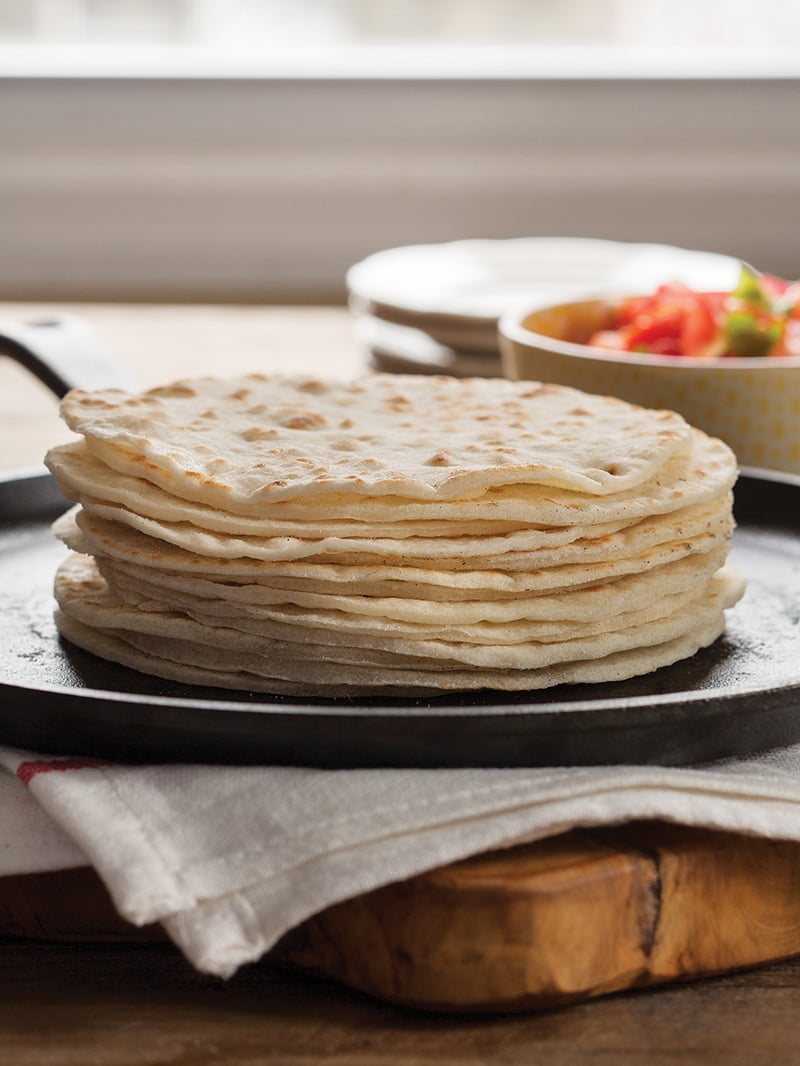 stack of gluten free tortillas on black skillet