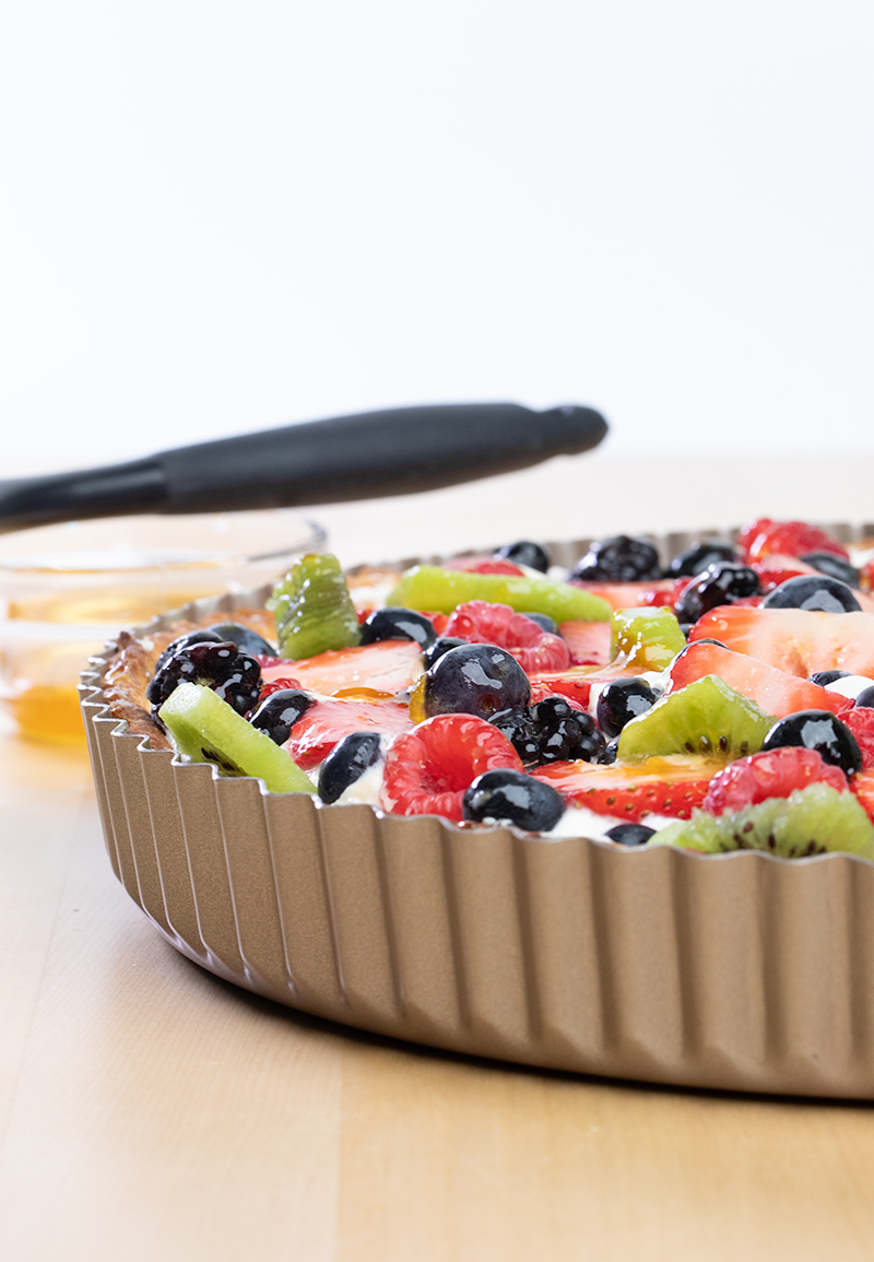 closeup image of side of gold colored tart pan used for fruit tart