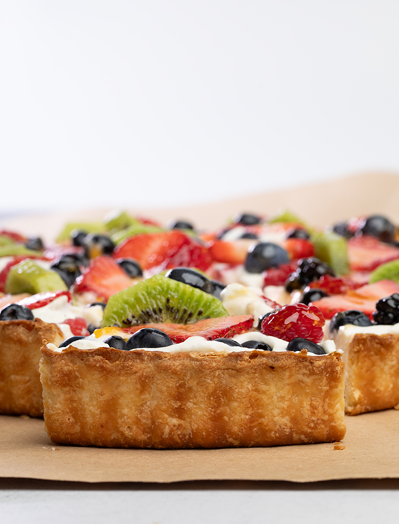 closeup image of browned back crust of slice of fruit tart on brown kraft paper