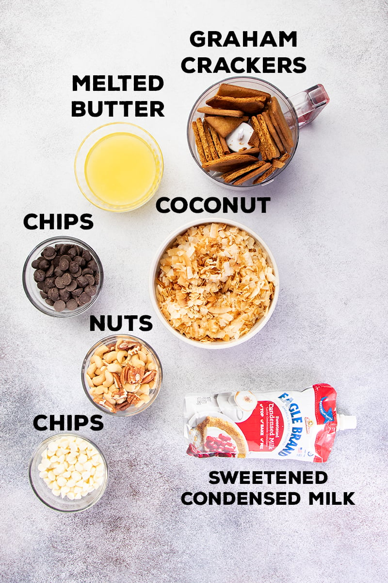 Ingredients for 7 layer bars in bowls with pouch of Eagle brand sweetened condensed milk