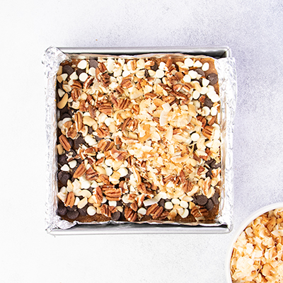 7 layer bars with nuts on top of chocolate and white chocolate chips