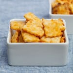 pile of square yellow cheese crackers in square white bowl