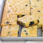 cut squares of pancakes with blueberries in gray sheet pan