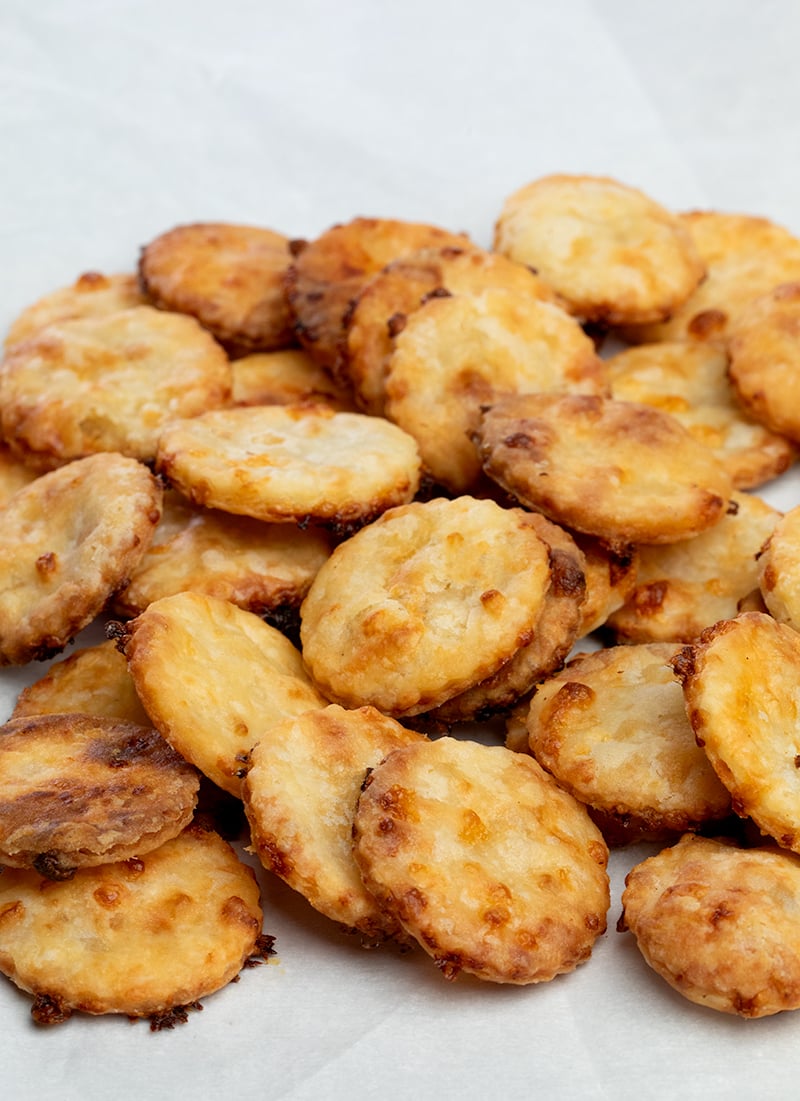 Pile of round cheese crackers on white paper