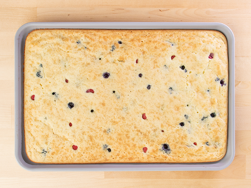 Sheet pan pancake with berries uncut in pan