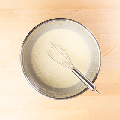 sheet pan pancake batter in bowl with whisk