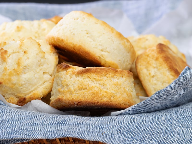 Light brown baked layered and drop gluten free biscuits on blue cloth