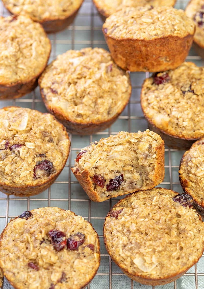 pile of baked oatmeal cups on wire rack with one cup broken