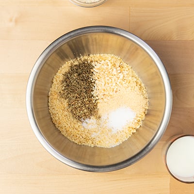 Breadcrumbs and spices in small round metal mixing bowl