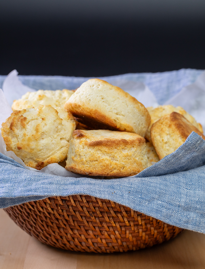 Brown bowl with blue cloth liner filled with round and drop biscuits