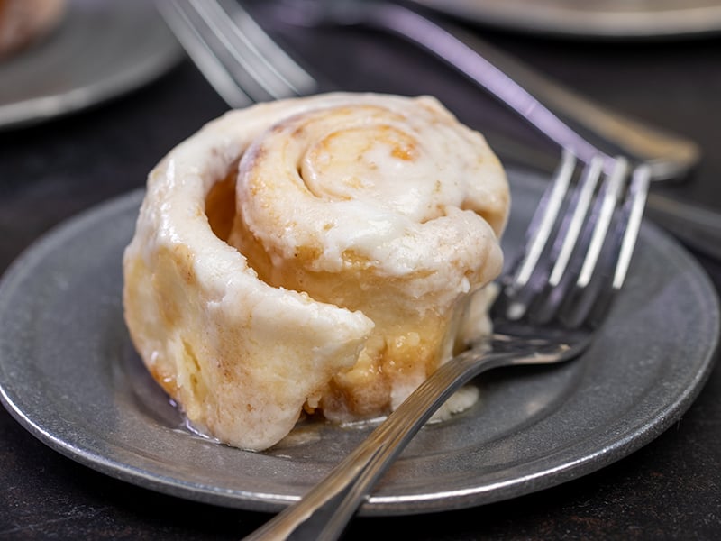 Cinnamon roll served on plate with fork