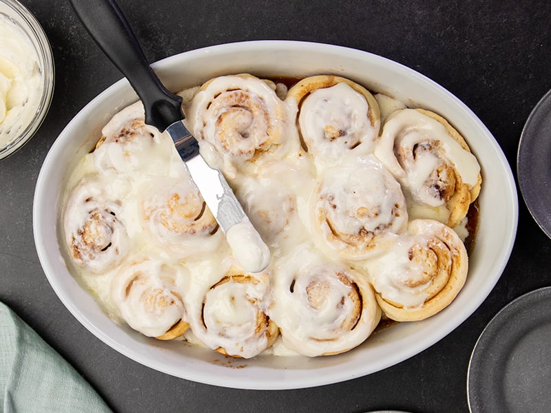 Cinnamon rolls being frosted